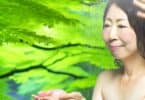 A calming image of a person standing under a soft rain, surrounded by nature, with peaceful expressions, symbolizing cleansing, renewal, and emotional release.