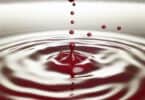 A striking image of droplets of blood falling into a pool of water, creating ripples that expand outward, symbolizing loss, sacrifice, and deep emotional conflicts.